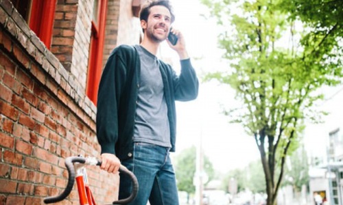 a person on a bicycle talking on a cell phone